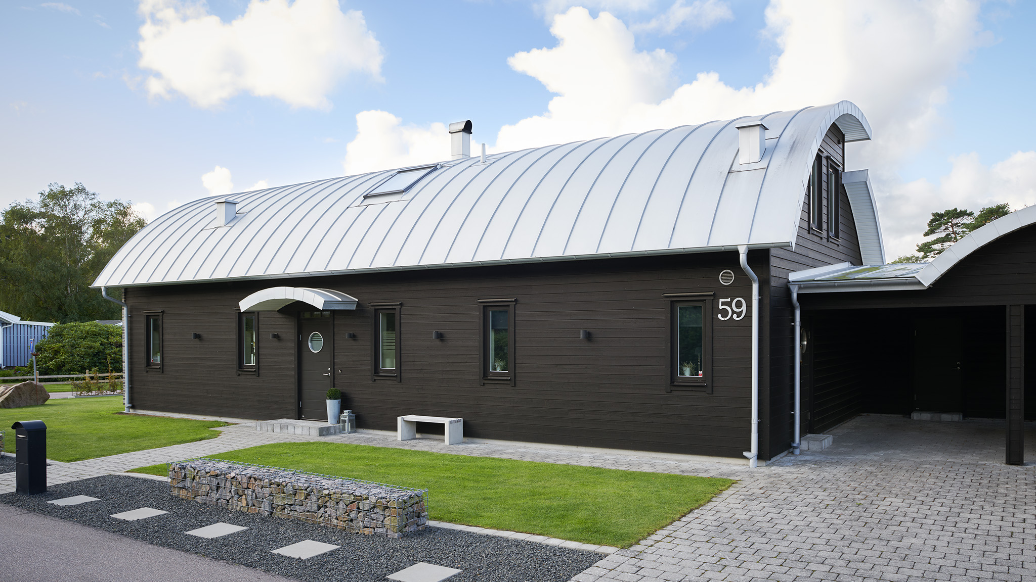 Brunsort husfarge med sort ytterdør og vinduskarmer Brunsort husfarge med sort ytterdør og vinduskarmer